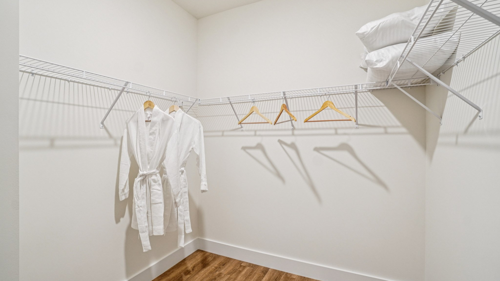 Primary suite walk-in closet in Saint Andrews Garth new home with built-in shelving and generous storage