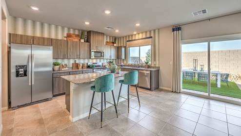 Our 2988 model kitchen in the Spectrum Falls Community with brown flat panel cabinets, Granite Slab countertops, a kitchen island, and Whirlpool Stainless Steel appliances.