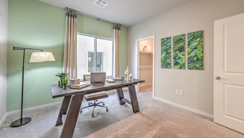 The Office/Bedroom Two option in our Spectrum Falls 2988 model with carpet flooring, a walk-in closet, and one large window, furnished with a desk and chair.