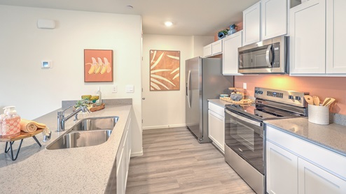 Our 1309 model kitchen in the Spectrum Trails Community with white shaker style cabinets, quartz countertops, and Whirlpool Stainless Steel appliances.