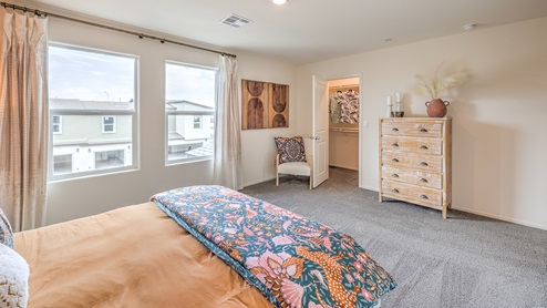 The Bedroom One Suite in our Spectrum Trails 1309 model with carpet flooring, a walk-in closet, windows, and recessed ceiling lights.