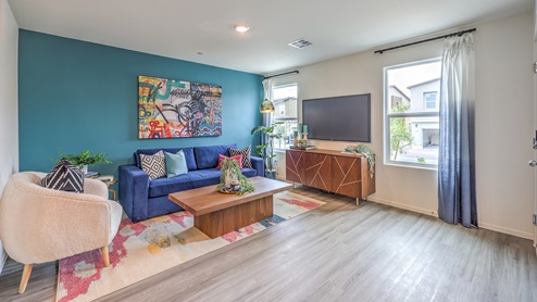 The Spectrum Trails 1309 Plan open concept Great Room with LVP panel flooring and a view of the kitchen.