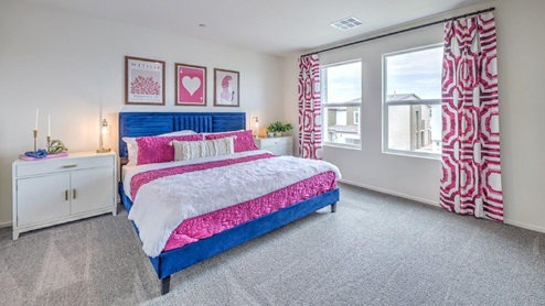 The Bedroom One Suite in our Spectrum Trails 1410 model with carpet flooring, a walk-in closet, windows, and recessed ceiling lights.
