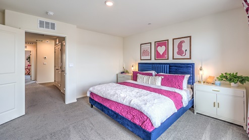 The Bedroom One Suite in our Spectrum Trails 1410 model with carpet flooring, a walk-in closet, windows, and recessed ceiling lights.