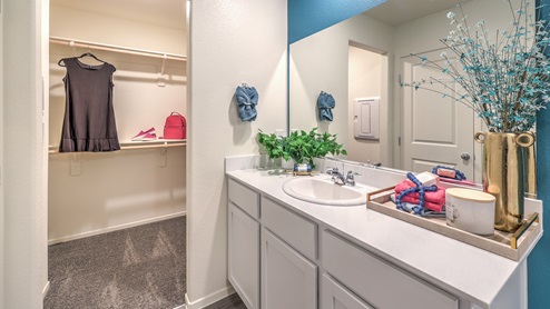 Attached to the Bedroom One Suite, our 1410 model bathroom with quartz/marble fusion countertops at the Bath Vanity, a walk-in shower, mirror, and grey cabinets.