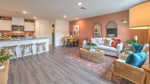 The Spectrum Trails 1309 Plan open concept Great Room with LVP panel flooring and a view of the kitchen.