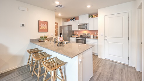 Our 1309 model kitchen in the Spectrum Trails Community with white shaker style cabinets, quartz countertops, and Whirlpool Stainless Steel appliances.