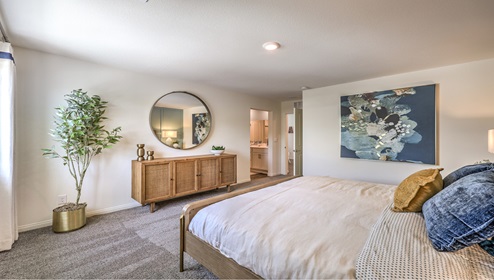 The Bedroom One Suite in our Cambria Bay 1865 model with carpet flooring, recessed ceiling lights, and a walk-in closet.