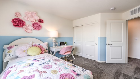Bedroom Four in our Cambria Bay 1865 model with carpet flooring, a sliding closet, and one window.