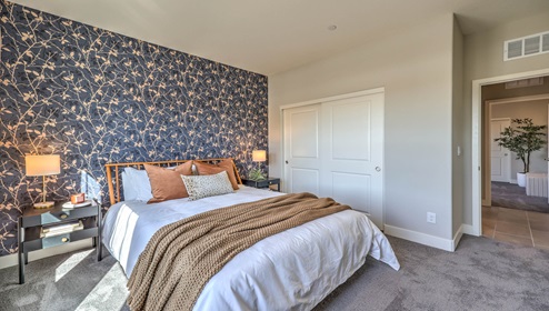 Bedroom Two in our Heartland Manor 2754 model with carpet flooring, a sliding closet, and a window.