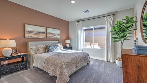 Bedroom Four in our Heartland Manor 2754 model with carpet flooring, a sliding closet, and a window.