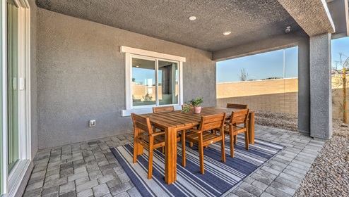 Our Symmetry Manor Manor 2754 model backyard with desert landscaping and a covered patio.