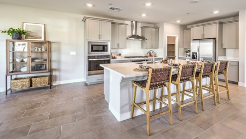 Our 2754 model kitchen in the Symmetry Manor Community with grey shaker style cabinets, granite countertops, a kitchen island, large pantry, and Whirlpool Stainless Steel appliances.