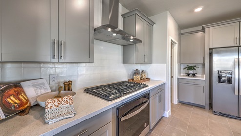 Our 2754 model kitchen in the Symmetry Manor Community with grey shaker style cabinets, granite countertops, a kitchen island, large pantry, and Whirlpool Stainless Steel appliances.
