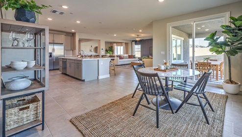 The Symmetry Manor 2754 model Dining Room adjacent to the kitchen and great room with a table and large window.
