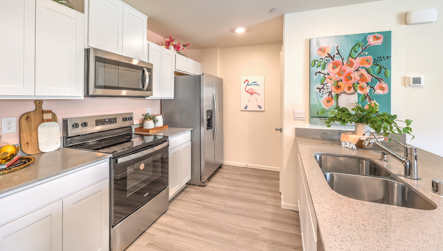 The Tempo Trails 1309 Plan open concept Great Room with LVP panel flooring and a view of the kitchen.