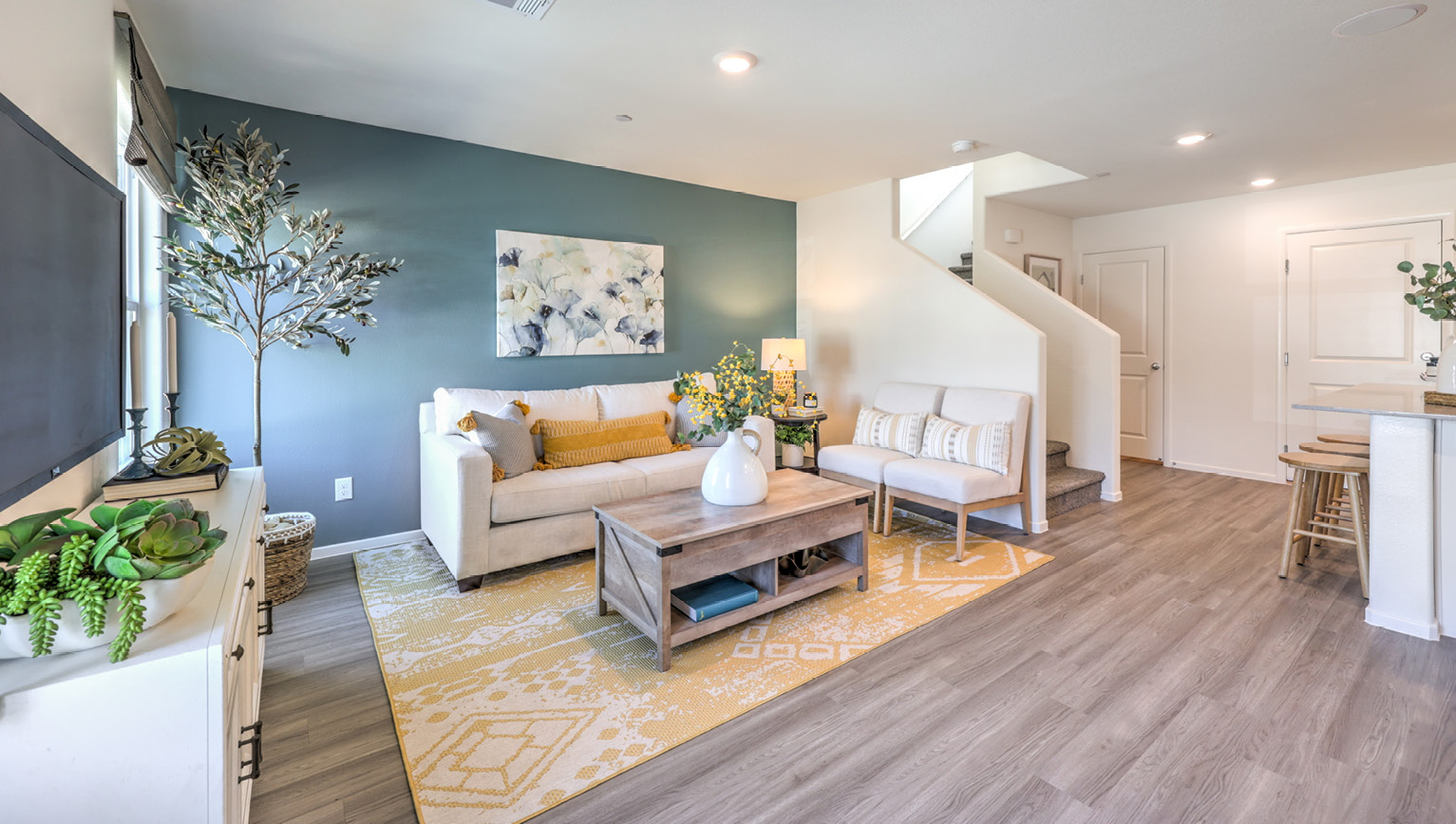 The Tempo Trails 1410 Plan open concept Great Room with LVP panel flooring and two windows.