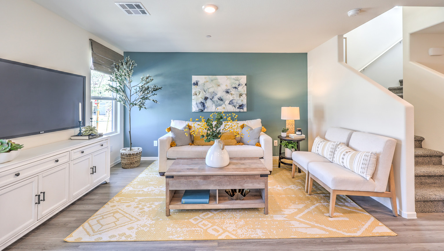 The Tempo Trails 1410 Plan open concept Great Room with LVP panel flooring and two windows.