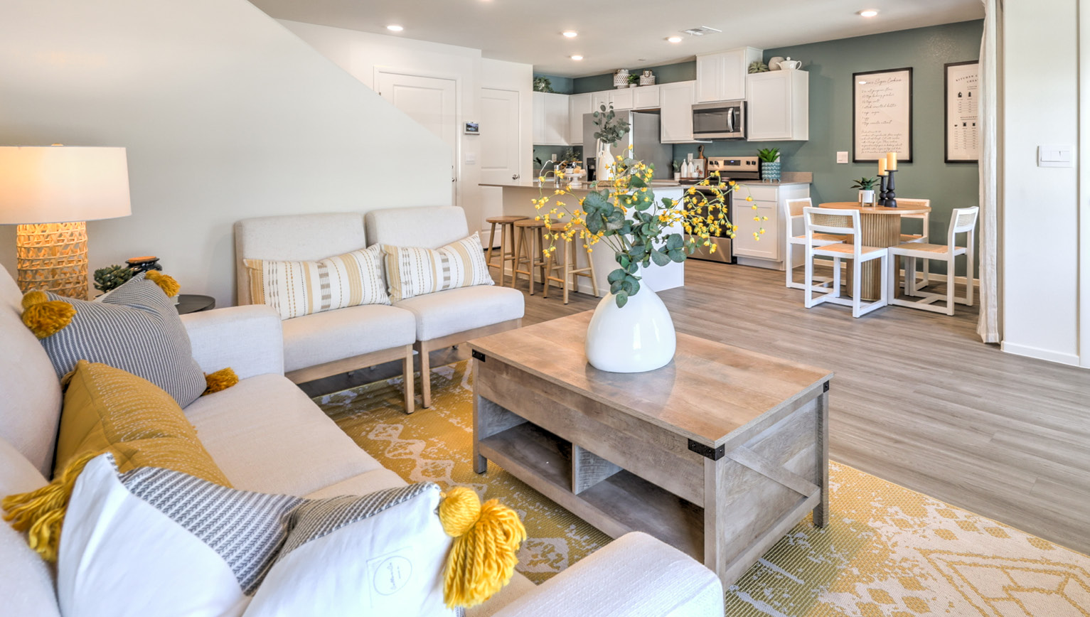 The Tempo Trails 1410 Plan open concept Great Room with LVP panel flooring and two windows.