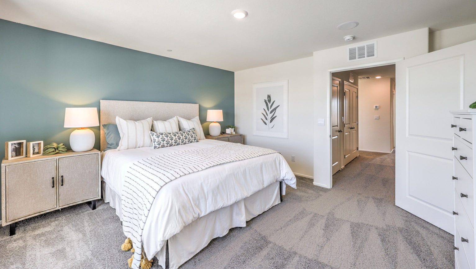 The Bedroom One Suite in our Tempo Trails 1410 model with carpet flooring, an accent wall, two windows.