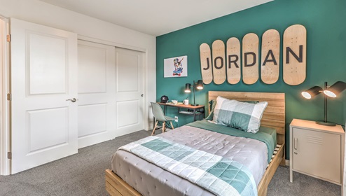 Bedroom Two in our Symmetry Bay 1865 model with carpet flooring, a sliding closet, and one window.