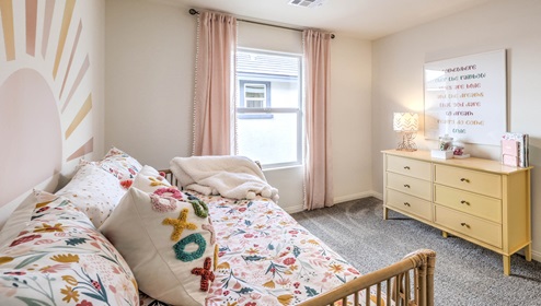 Bedroom Three in our Symmetry Bay 1865 model with carpet flooring, a sliding closet, and one window.