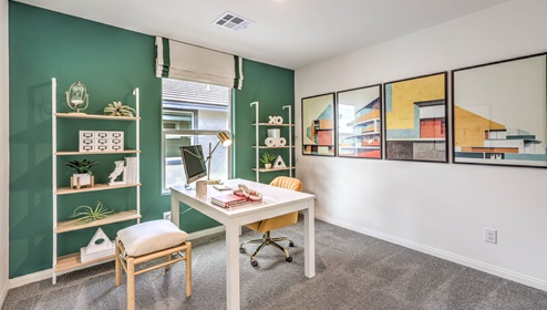 The Office/Bedroom Four option in our Symmetry Bay 1865 model with carpet flooring, a sliding closet, and a window, furnished with a desk and chair.
