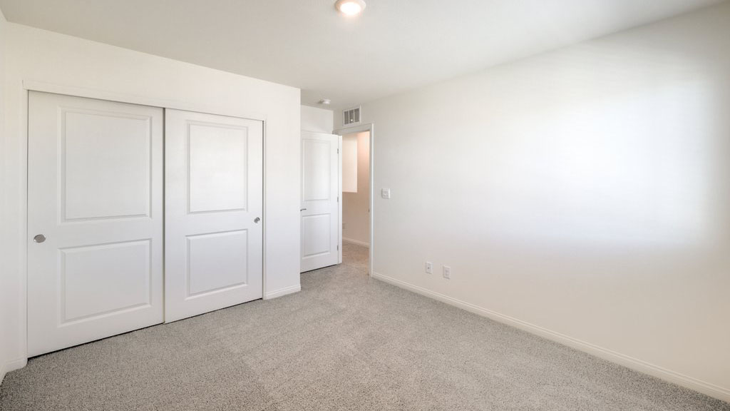 Bedroom Two in our Symmetry Bay 1715 model with carpet flooring and one window.