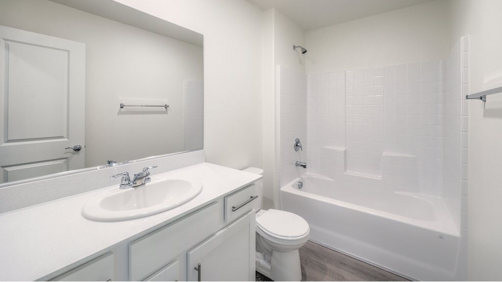 The Bedroom Three option in our Symmetry Bay 1715 model with carpet flooring, a sliding closet, and a window, furnished with a desk and chair.