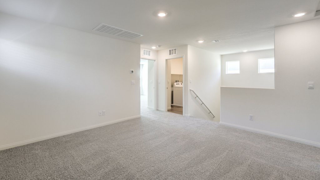 The upstairs loft in our Symmetry Bay 1715 model with carpet flooring and a closet.