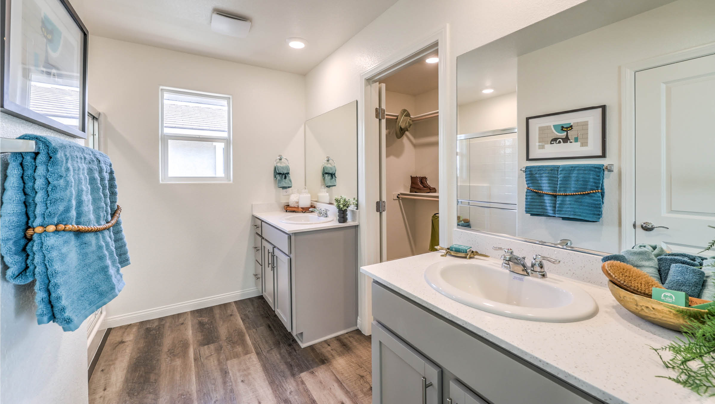 Attached to the Bedroom One Suite, our 1802 model bathroom with granite countertops at the double Bath Vanity, a walk-in shower, walk-in closet, mirror, and grey cabinets.