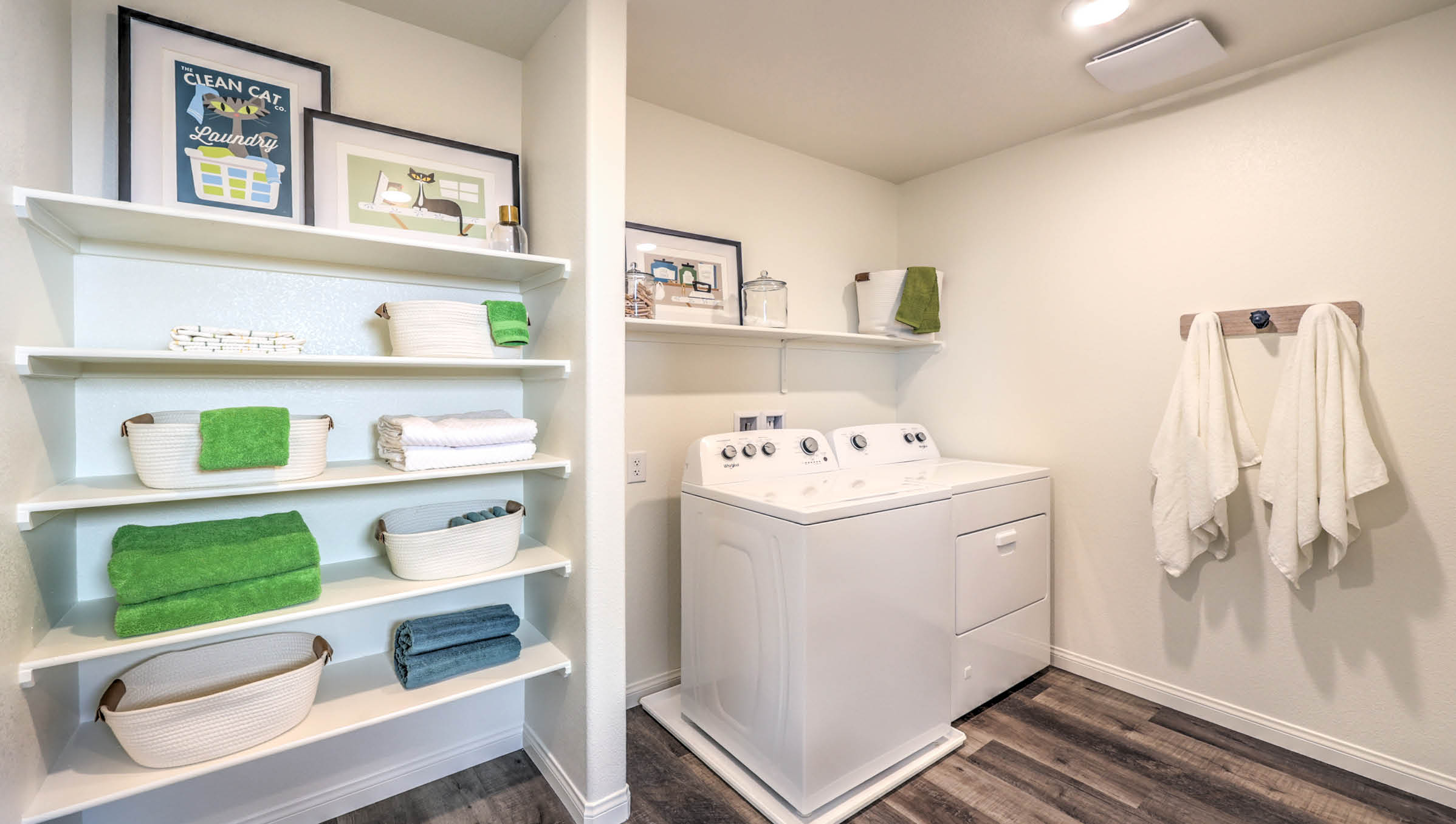 Our Symmetry Bay 1802 model laundry room with shelves and a washer and dryer.
