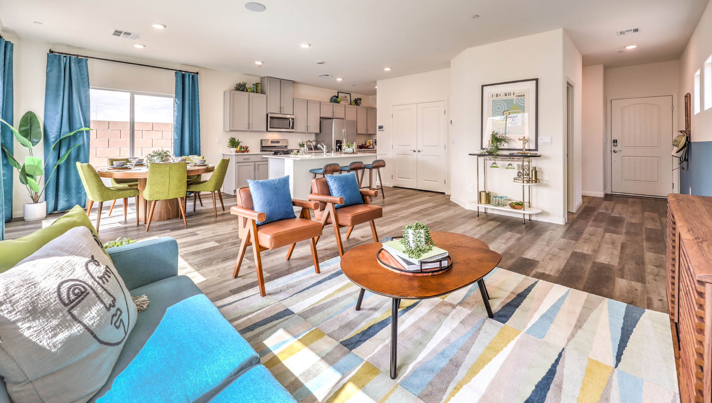 The Symmetry Bay 1802 Plan open concept Great Room with LVP panel flooring and a sliding door to the backyard.