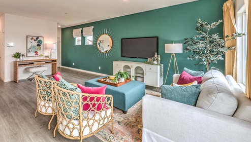The Symmetry Bay 1865 Plan open concept Great Room with LVP panel flooring, two large windows, and a sliding door to the backyard.