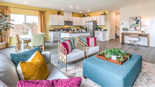 The Symmetry Bay 1865 Plan open concept Great Room with LVP panel flooring, two large windows, and a sliding door to the backyard.