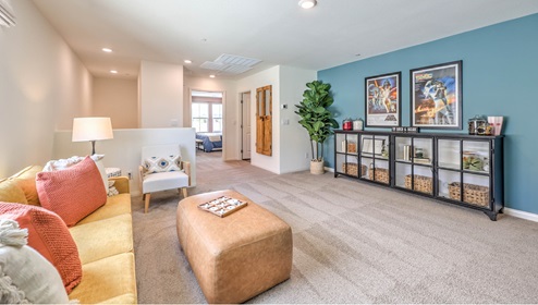 The Symmetry Falls 3000 Model Loft featuring wall-to-wall carpet, recessed lighting, and an open layout ideal The space is located on the upper level and offers flexibility for a variety of lifestyle needs, with natural light from adjacent rooms enhancing the bright, airy feel.