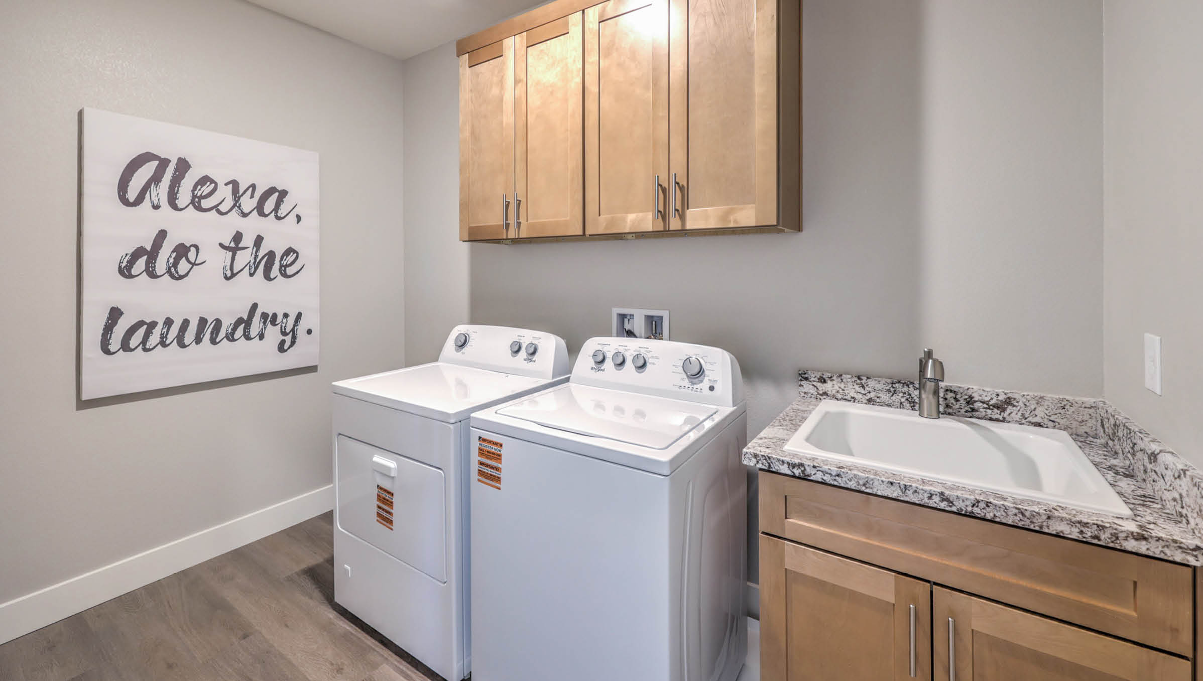 Our Symmetry Summit 3765 model laundry room with cabinets and a washer and dryer.