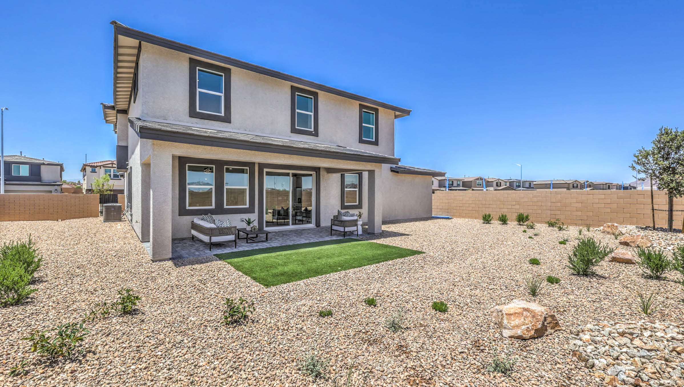 Our Symmetry Summit 3765 model backyard with landscaping and a large covered patio.