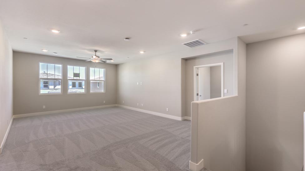 The upstairs loft in our 3825 model with carpet flooring and large windows.