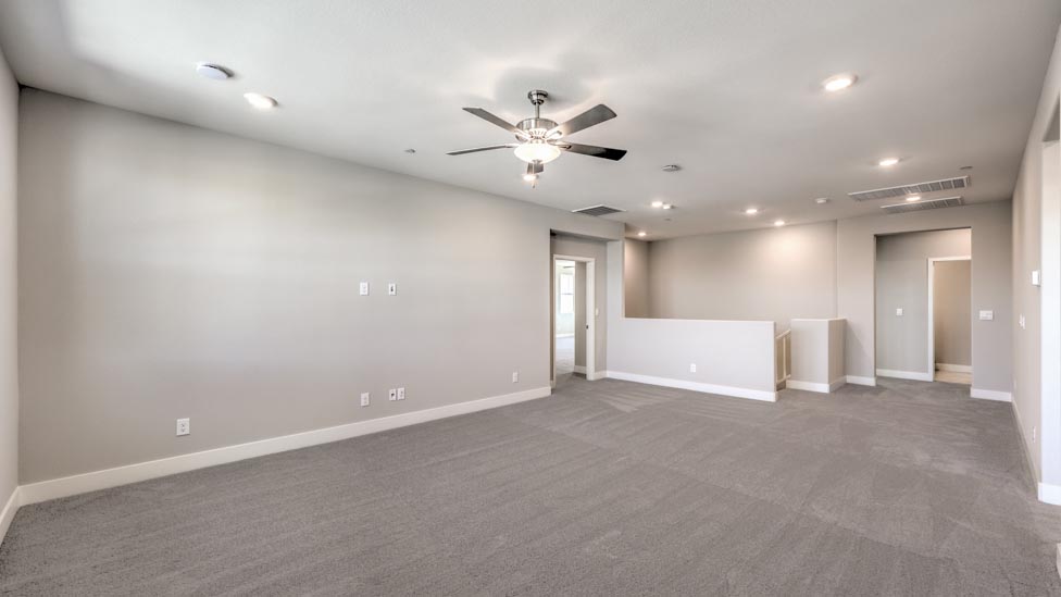 The upstairs loft in our 3825 model with carpet flooring and large windows.