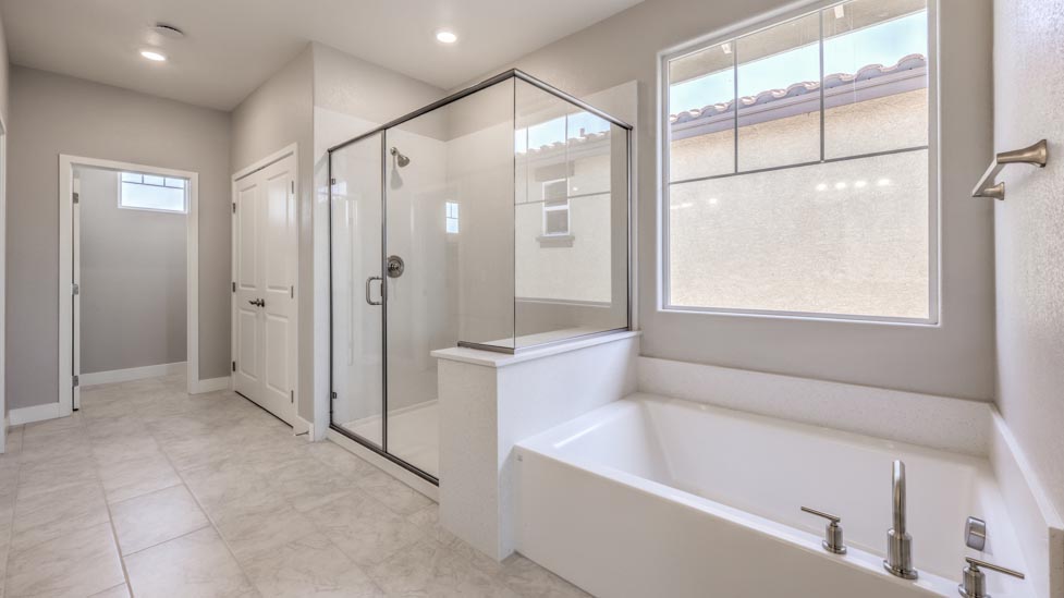 Attached to the Bedroom One Suite, our 3825 model bathroom with a walk-in shower and bath tub.