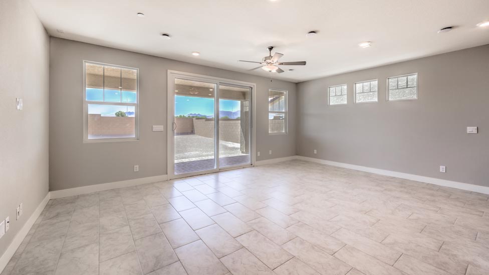 The Symmetry Summit 3825 Plan open concept Great Room with ceramic tile flooring, large windows, and a sliding door to the backyard.