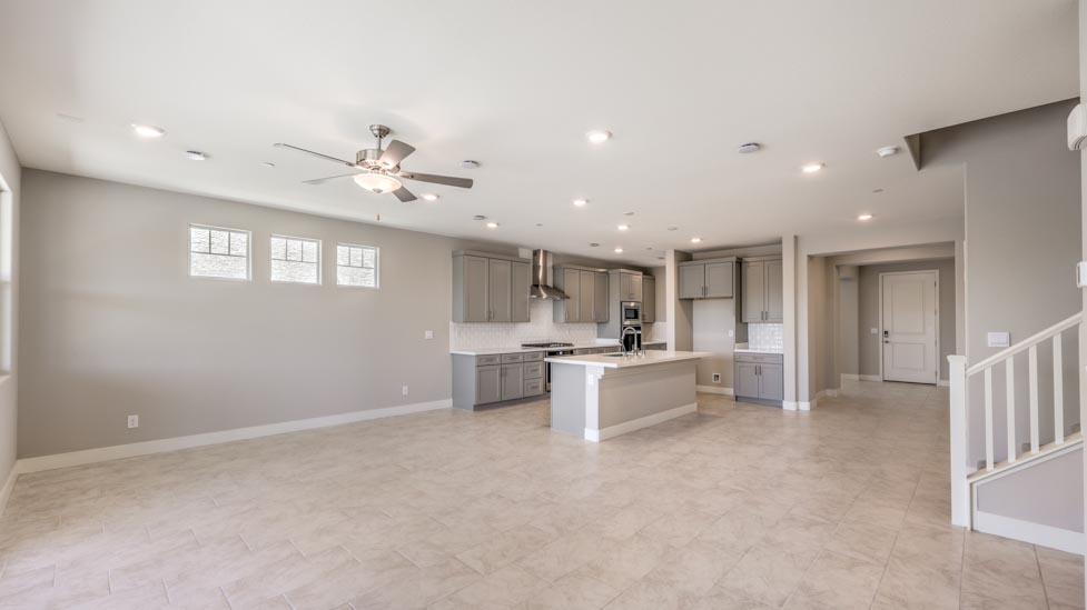 The Symmetry Summit 3825 Plan open concept Great Room with ceramic tile flooring adjacent to the kitchen.