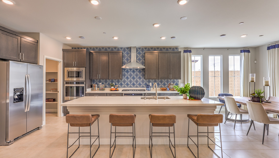Our 4425 model kitchen in the Symmetry Summit Community with a kitchen island seating area.