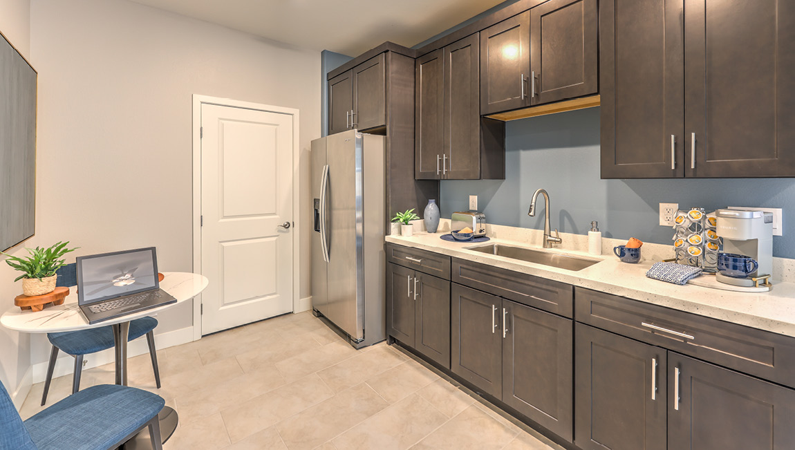 Our Symmetry Summit 4425 Multigen with a Whirlpool stainless steel refrigerator, sink, shaker style cabinets, and quartz countertops.