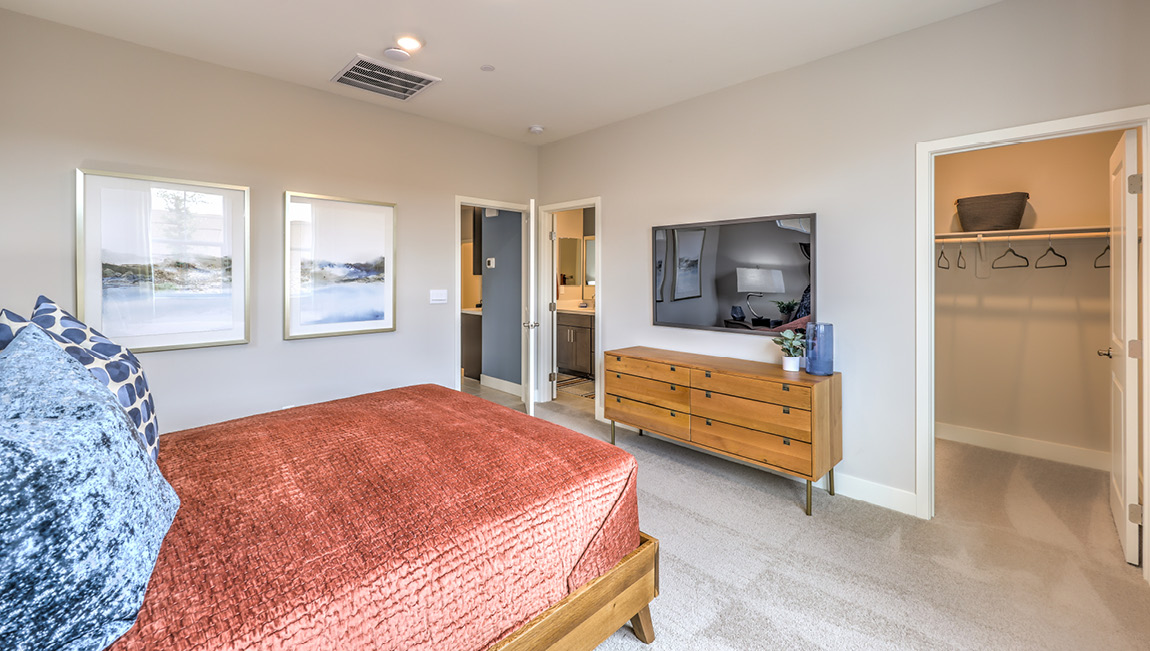 Bedroom Six in our Symmetry Summit 4425 Multigen Suite with carpet flooring, a walk-in closet, and five windows.