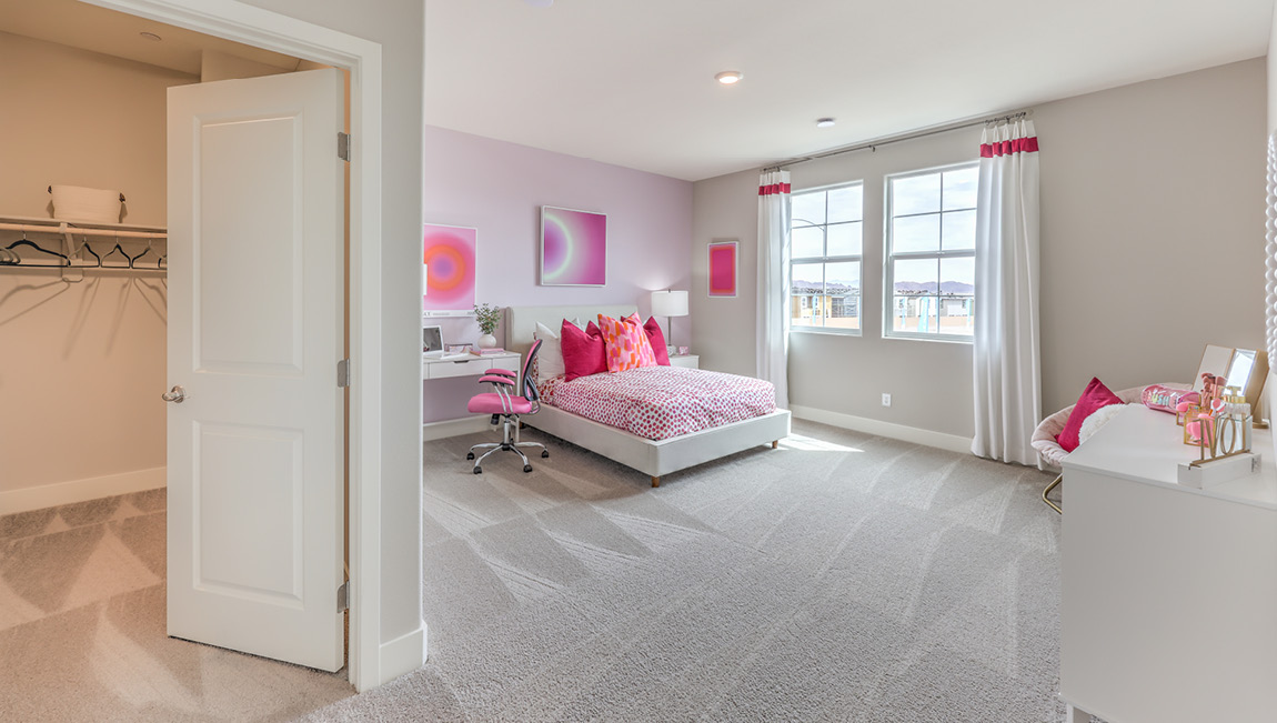 Bedroom Two in our Symmetry Summit 4425 model with carpet flooring, a walk-in closet, and two windows.
