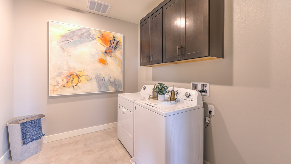 Our Symmetry Summit 4425 model laundry room with cabinets and a washer and dryer.