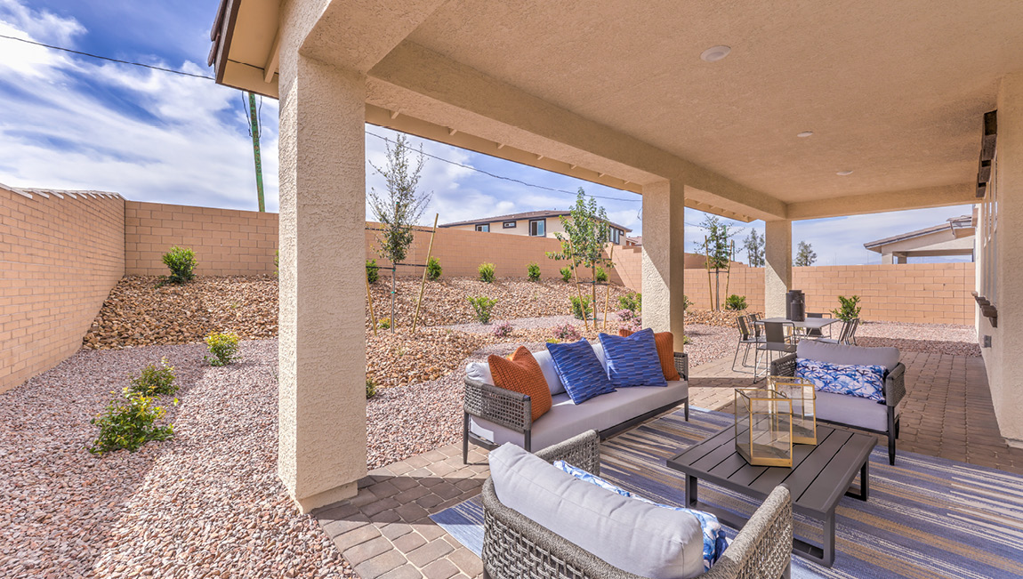 Our Symmetry Summit 4425 model backyard with landscaping and a large covered patio.