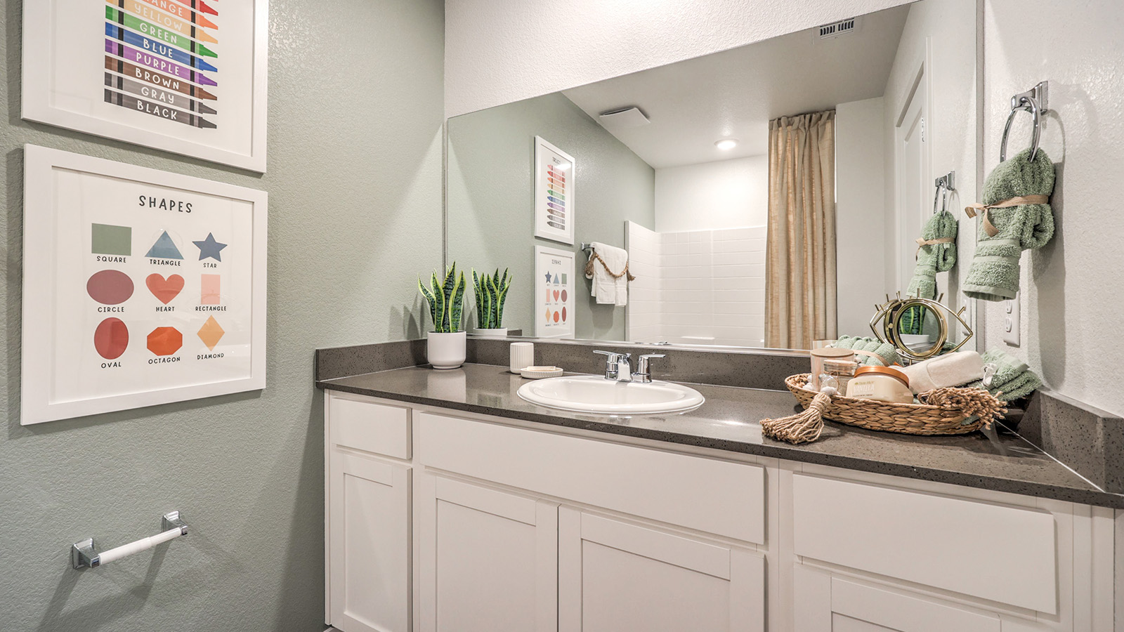Bathroom Two in our Symmetry Trails 1410 model with quartz/marble fusion countertops at the Bath Vanity, a shower, mirror, and white cabinets.